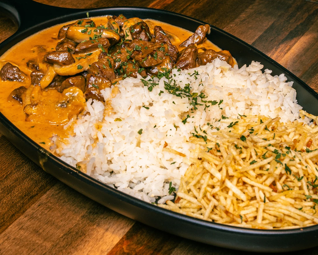 Brazilian strogonoff in Lake Nona — creamy beef stroganoff over white rice topped with crispy batata palha at Kingdom BBQ & Grill