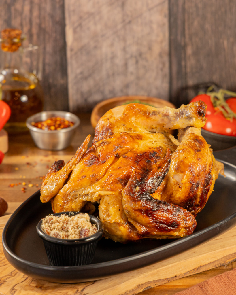 Fire roasted chicken at Kingdom BBQ Grill in Lake Nona — a juicy slow-roasted whole bird with Brazilian sides of rice, beans and vinaigrette