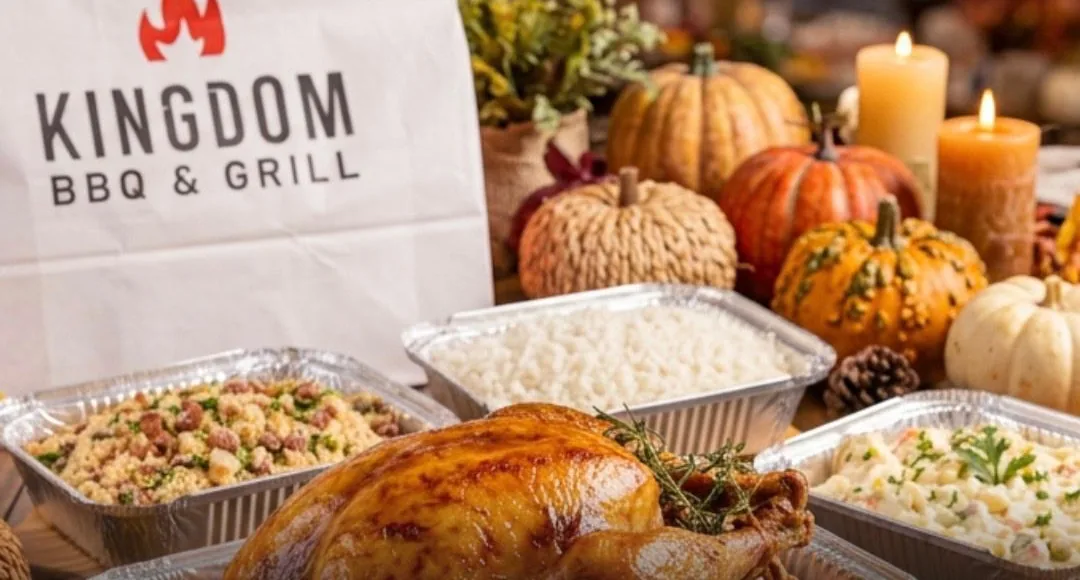 Thanksgiving table with a roasted turkey, farofa, white rice, potato salad and a Kingdom BBQ bag among pumpkins and candles