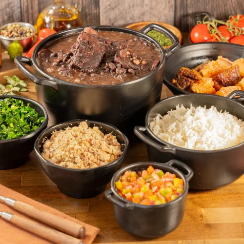 Traditional Brazilian feijoada completa with rice, farofa and collard greens