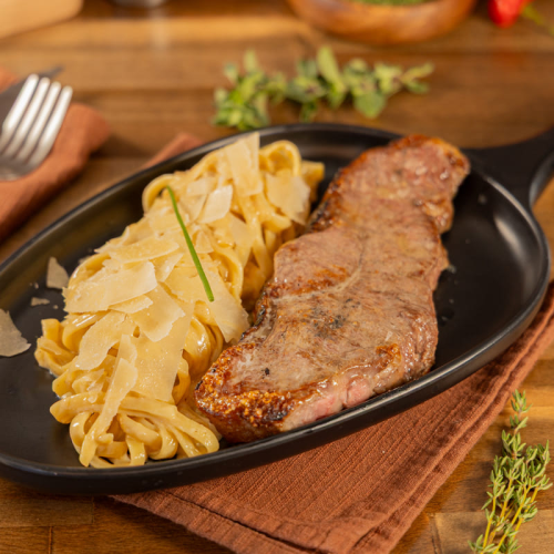 New York strip steak with fettuccine alfredo served at Kingdom BBQ & Grill in Orlando