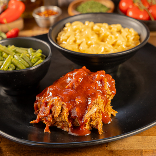 Brazilian BBQ group order with pulled pork and traditional sides from Kingdom BBQ & Grill